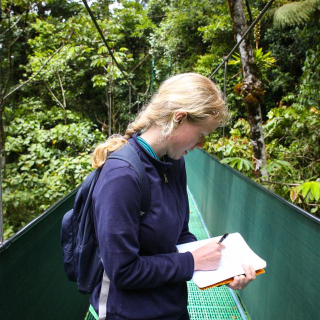 girl taking notes in a forest