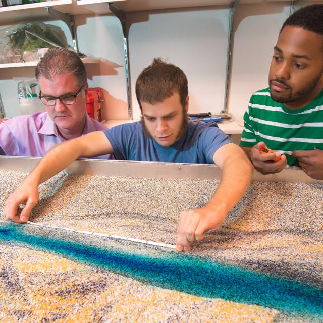 students looking at a river model