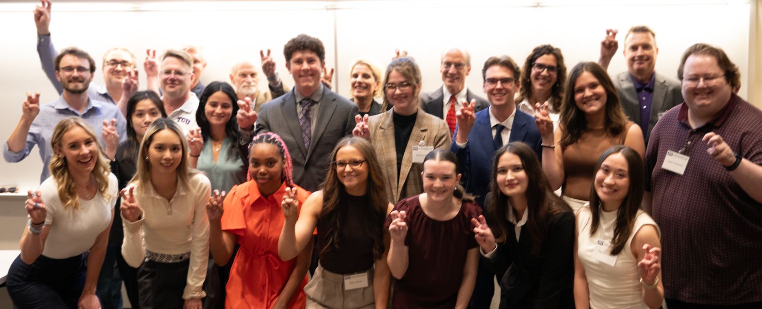 Students and faculty do the Horned Frog hand sign for a group photo for SRS.