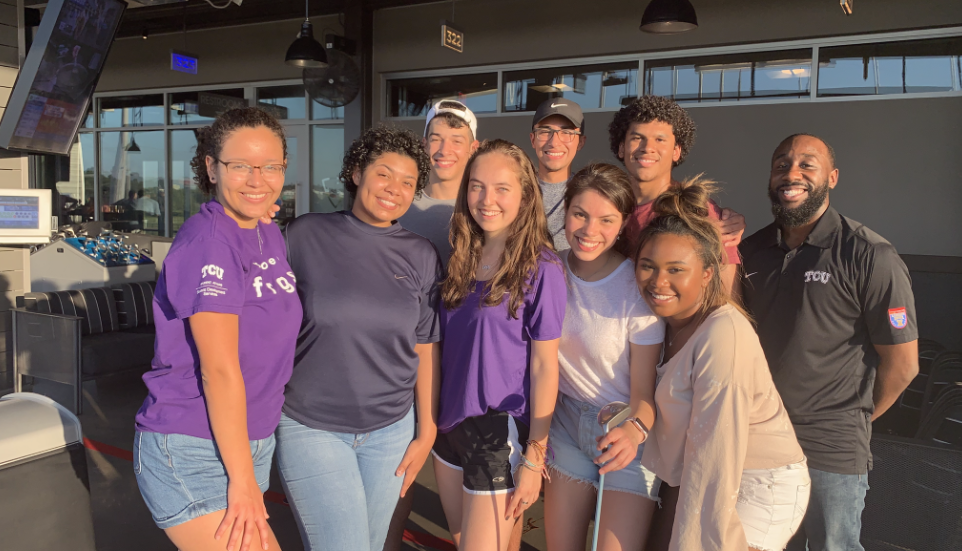 Nine STEM Scolars grouped together at Topgolf with one holding a golf club