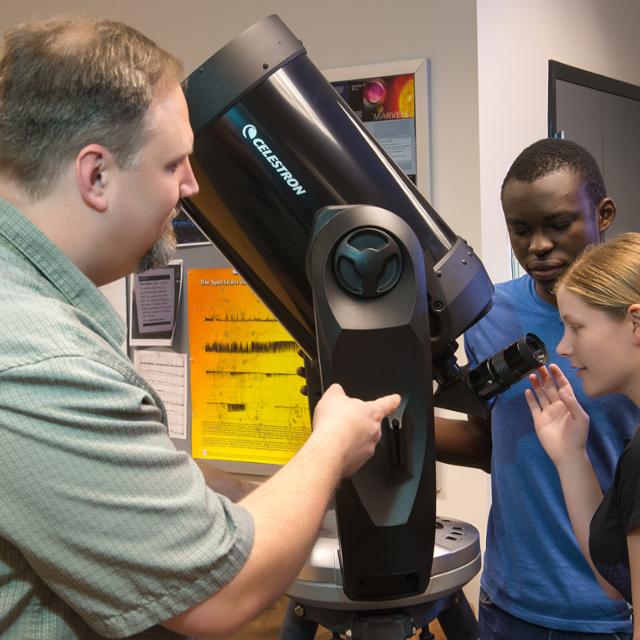 students looking through a telescope