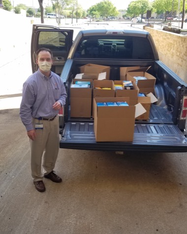 Ben Barkley Moncrief next to a truck loaded with PPE