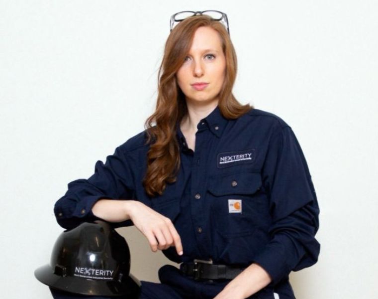 An individual wearing a dark blue work uniform with 