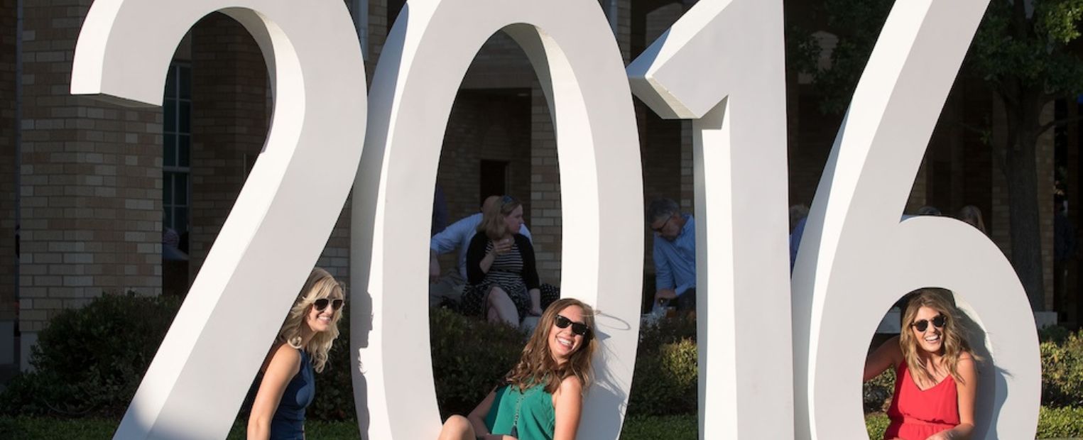 Three girls pose by 2016 sign.